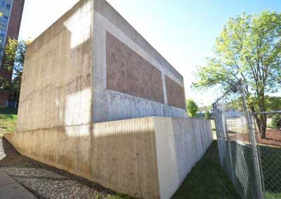 Before, ribbed concrete panels, soiled, clay colored block, efflorescence, and rain stains